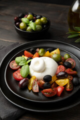Buffalo mozzarella or burrata cheese with tomatoes and olivesl italian food, caprese salad