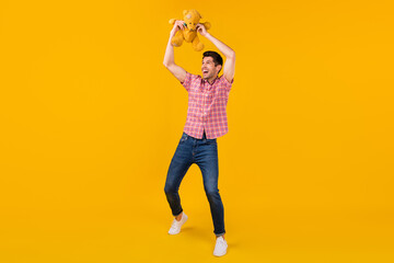 Fototapeta na wymiar Full body photo of positive happy man raise bear toy good mood look empty space isolated on yellow color background