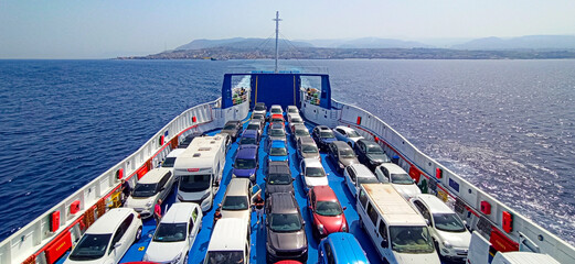 many cars on the ferry with Calabria on the bottom. Departure for holidays.Strait of Messina