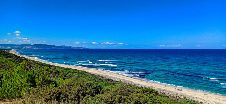 Budoni beach, Sardinia, Italy. Mediterranean scrub, empty beach and blue sea.