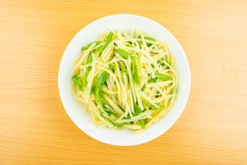 A dish of homemade green pepper and potato shreds on the table