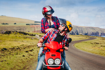 Happy Couple riding a motorbike. Young hipster riders enjoying the trip. Adventure and vacations concept