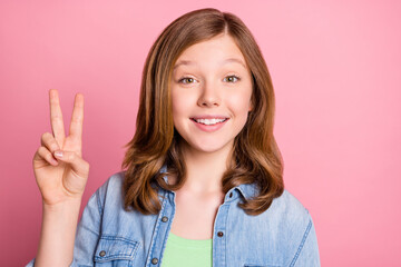 Photo portrait girl showing v-sign gesture smiling isolated pastel pink color background