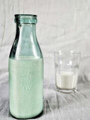 rustic still life with a bottle amd glass of milk on the white background with copy space