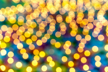 Golden circular blur light bokeh abstract on a blurred blue background. Holiday concept backdrop with twinkling bright shapes.Blinking Christmas