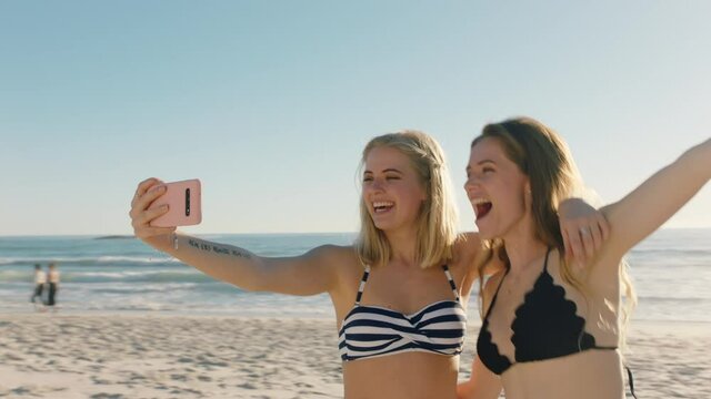best friends taking selfie photo on beach using smartphone teenage girls sharing summer vacation enjoying summertime by the sea