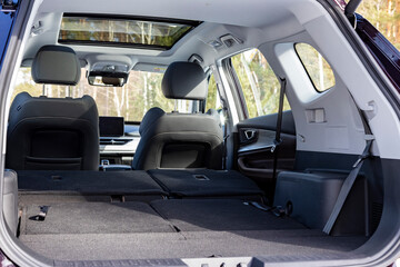a huge car interior with the rear seats folded down. large luggage compartment of a family car. car folding seats and large volume empty car trunk and special storage compartment