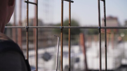 the worker twists the reinforcement with wire at the construction site