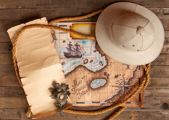 still life with a cork helmet with an old treasure map on a wooden table top view