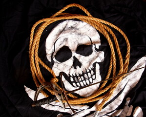 black pirate flag jolly roger blank blank rope and sword close up