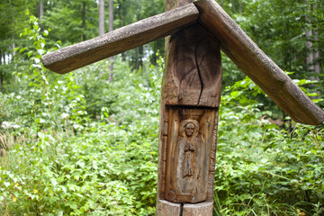 Ręcznie wyrzeźbiona w drewnie kapliczka w lesie