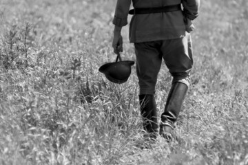 idący z hełmem w ręku żołnierz kampani wrześniowej 1939 roku , rekonstrukcja historyczna