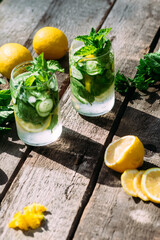 Lemonade with lemon, mint, cucumber and ice in a glass