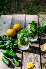Lemonade with lemon, mint, cucumber and ice in a glass