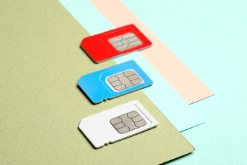 Different SIM cards on color background, closeup