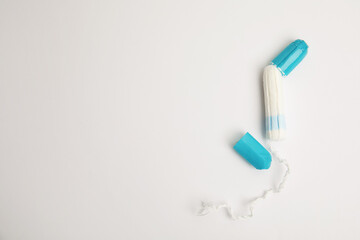 Tampon with package on light background, flat lay. Space for text