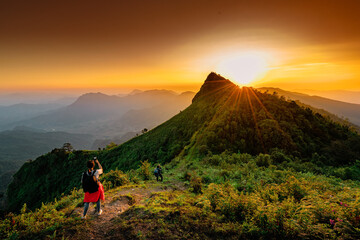 Woman with backpack from behind and beautiful Landscape of mountain with sunset in Chiang Rai,...