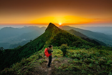 Traveler with backpack from behind and beautiful Landscape of mountain with sunset in Chiang Rai, Thailand