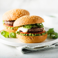Traditional homemade beef burgers with pesto sauce