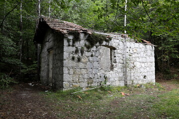 Old abandoned house located along the path around the Molveno lake. Trentino, Italy.