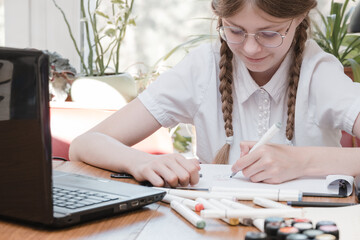 Schoolgirl self isolation using laptop for his homework. Girl doing using digital tablet searching...