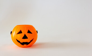 Candy basket in the shape of halloween lantern pumpkin on white background. Selective focus. Copy space.