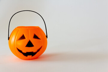 Candy basket in the shape of halloween lantern pumpkin on white background. Selective focus. Copy space.