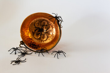 Old cauldron with toy spiders. Halloween background. Selective focus. Copy space.