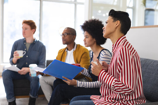 Diverse male and female colleagues working together, discussing in casual meeting