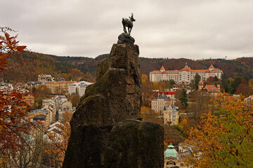 Karlovy Vary famous chamois statue, symbol of spa town in autumn atmosphere with yellow coloured...