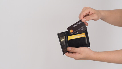Hand is hold Black credit card and gold color in black wallet isolated on white background.