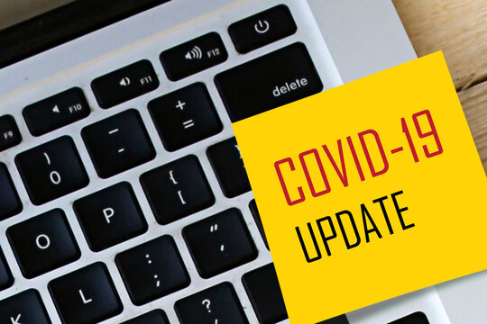 COVID-19 UPDATE sticker text on laptop keyboard
