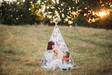 Family, leisure and ethnic people concept. Boho hippie happy mother and little daughter having...