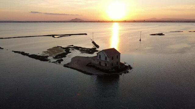 House isolated by water in mediterranean sea drone view. Lonely house in island surrounded by water as a consecuence of sea level growth due to melt down of polar ice, defrostation. 