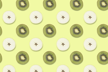 Creative seamless pattern made of kiwi and slices of apple, flat lay. Food concept on yellow background