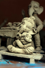 Fototapeta na wymiar Closeup of unfinished clay model of Lord Ganesh\Ganesha holding modak, his favorite sweet 
