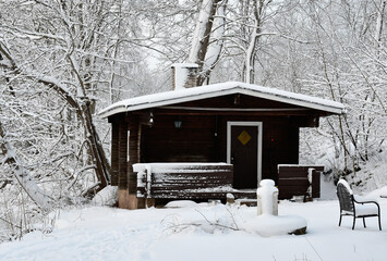 Old log sauna by the lake in winter