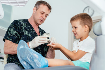 Doctor orthodontist tells the child how to care for teeth and maintain hygiene