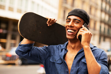 African man with skateboard. Young handsome man talking to the phone