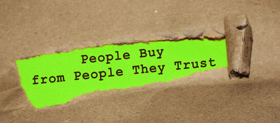 Motivational quote People Buy From People They Trust, appearing behind torn paper