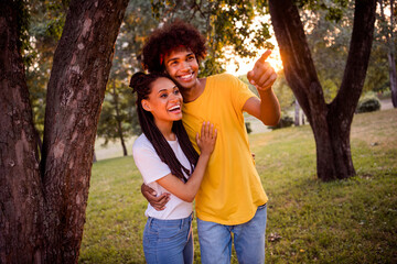 Fototapeta premium Portrait of attractive cheerful couple having fun hugging showing horizon far away getaway trip spending weekend at forest outdoors