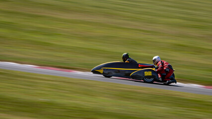 A panning shot of a racing kart as it circuits a track.