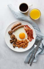 Vertical of delicious irish breakfast. Classic irish cuisine on white plate. Fried eggs, grilled...