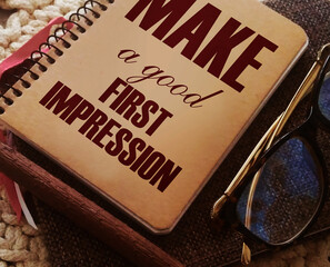 Make a Good First Impression written on book cover, eyeglasses and pen. Business career motyvation...