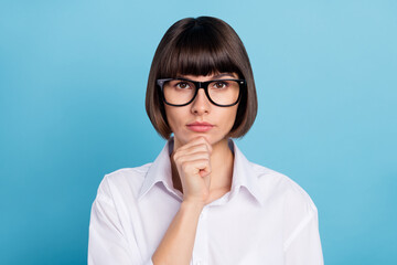 Fototapeta premium Portrait of attractive serious skilled pensive girl specialist thinking touching chin isolated over bright blue color background