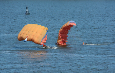 Two parachutists water just landing