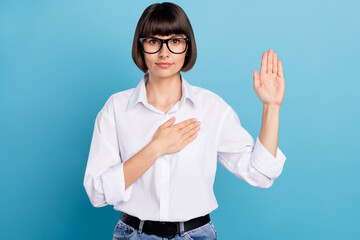 Portrait of attractive honest girl touching heart saying oath isolated over vibrant blue color background