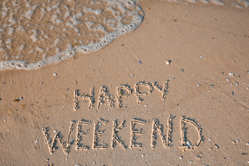 Phrase Happy weekend written on sand at beach, top view