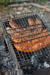 Delicious barbecue pork sausages flame grilled outdoor. Quick tasty campfire cooking. BBQ in the garden. Bavarian sausages