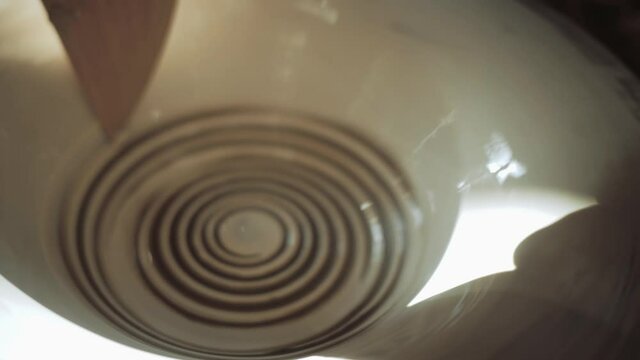 Giving a spiral pattern to a plate on a potter's wheel. High quality 4k footage